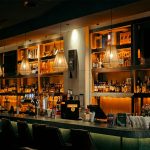 Stimmungsvoll beleuchteter Bar-Tresen mit Spirituosenflaschen
