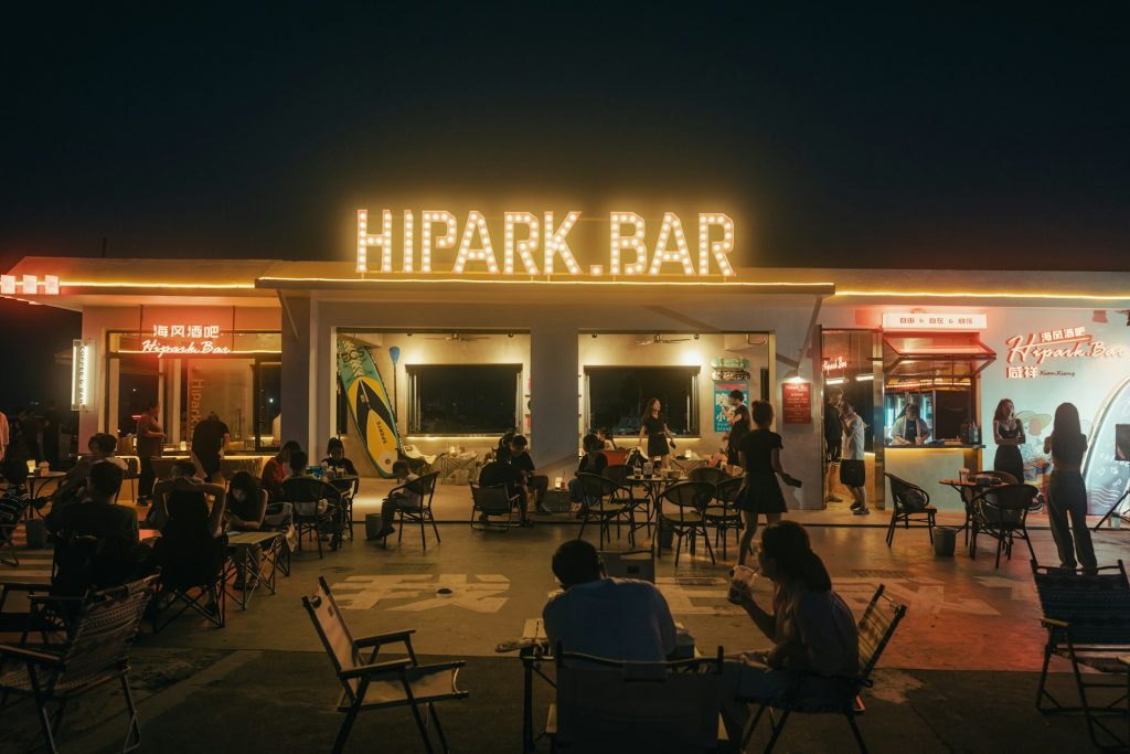 Gruppe von Gästen abends vor einer Bar